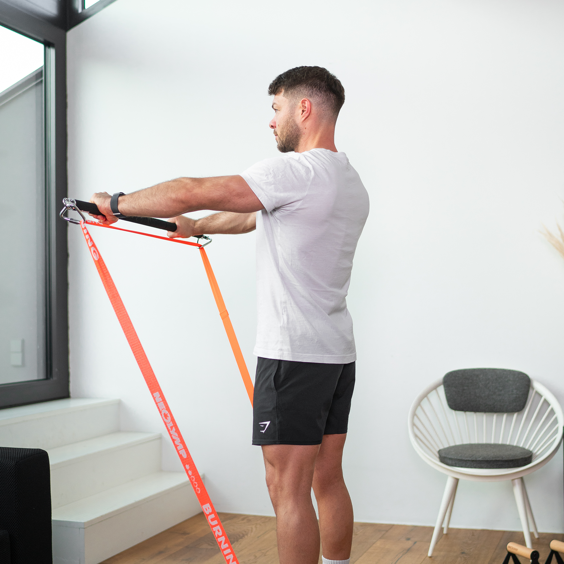 Ein Mann führt mit Widerstandsband, das an einer Bänderstange befestigt ist, eine Übung durch